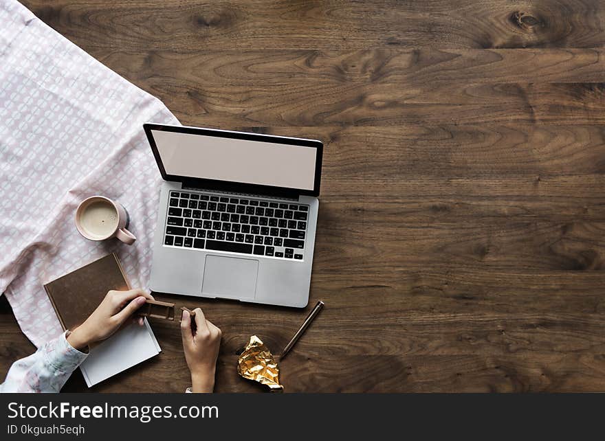 Person Holding Chocolate Bar Near Laptop