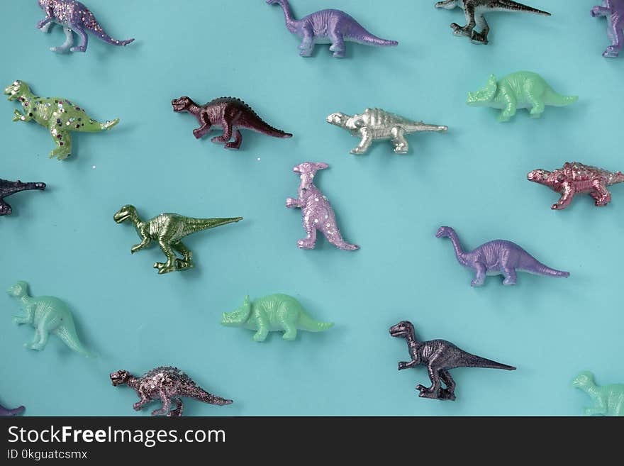 Assorted-color Plastic Dinosaur Figurine Lot on Teal Surface