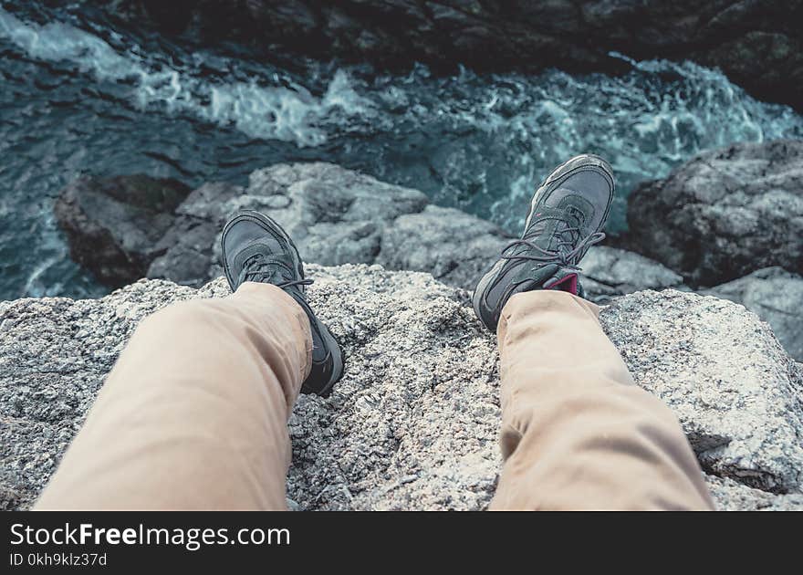 Photo of Man Sitting on the Cliff