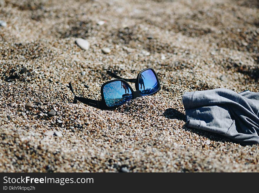 Close-Up Photography of Sunglasses on Sand