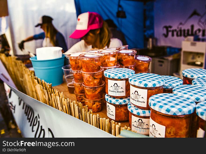 Woman Selling Canned Food on Display Table