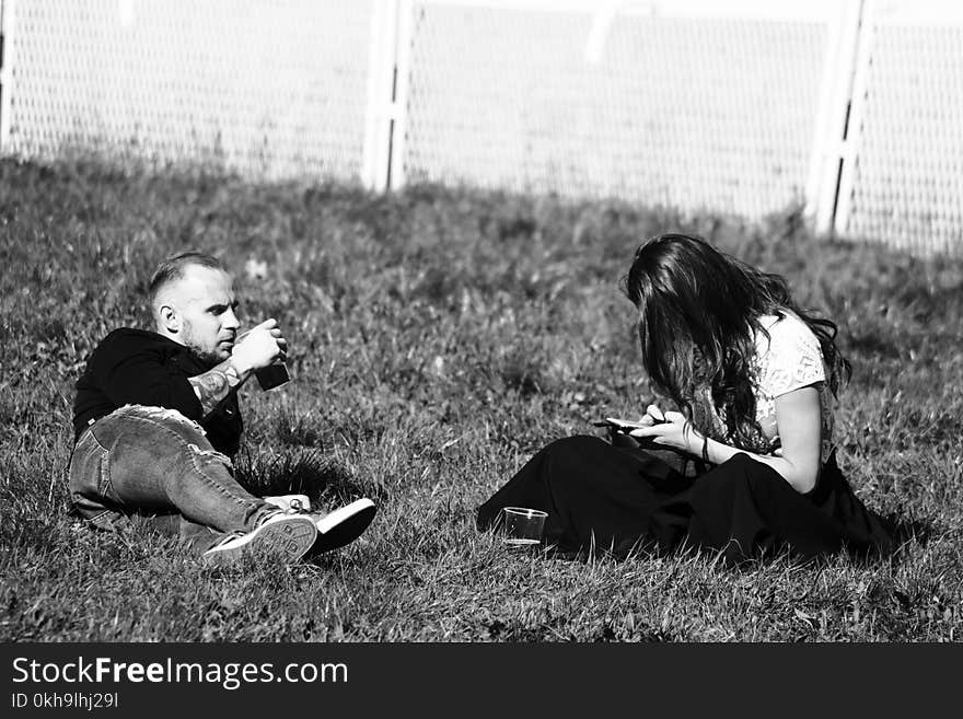 Grayscale Photography of Man and Woman on Grass