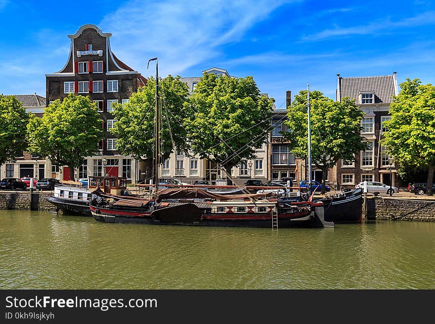 Sailboat on Dock Near Brown and Red Buildings