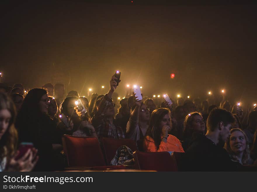 Photo of People Holding Smartphones With Flashlight