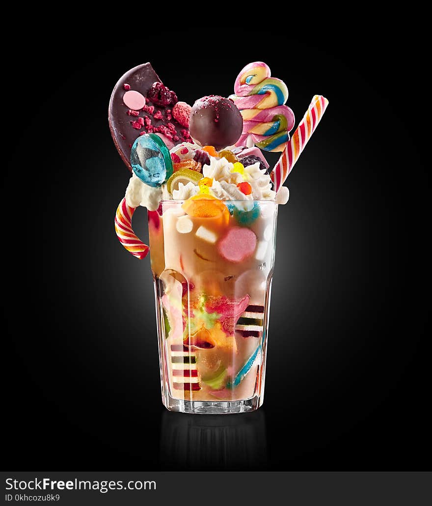 Monster shake, freak caramel shake. Colourful, festive milk shake cocktail with sweets, candy, jelly. Colored caramel milkshakes array of different childs sweets and treats in glass on white background. Sweet candy milkshake. Crazy freakshake food trend isolated. Monster shake, freak caramel shake. Colourful, festive milk shake cocktail with sweets, candy, jelly. Colored caramel milkshakes array of different childs sweets and treats in glass on white background. Sweet candy milkshake. Crazy freakshake food trend isolated.