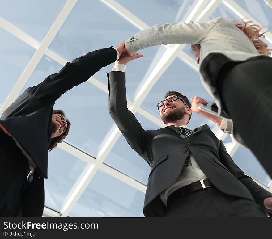 Happy business team giving high five in office. Happy business team giving high five in office