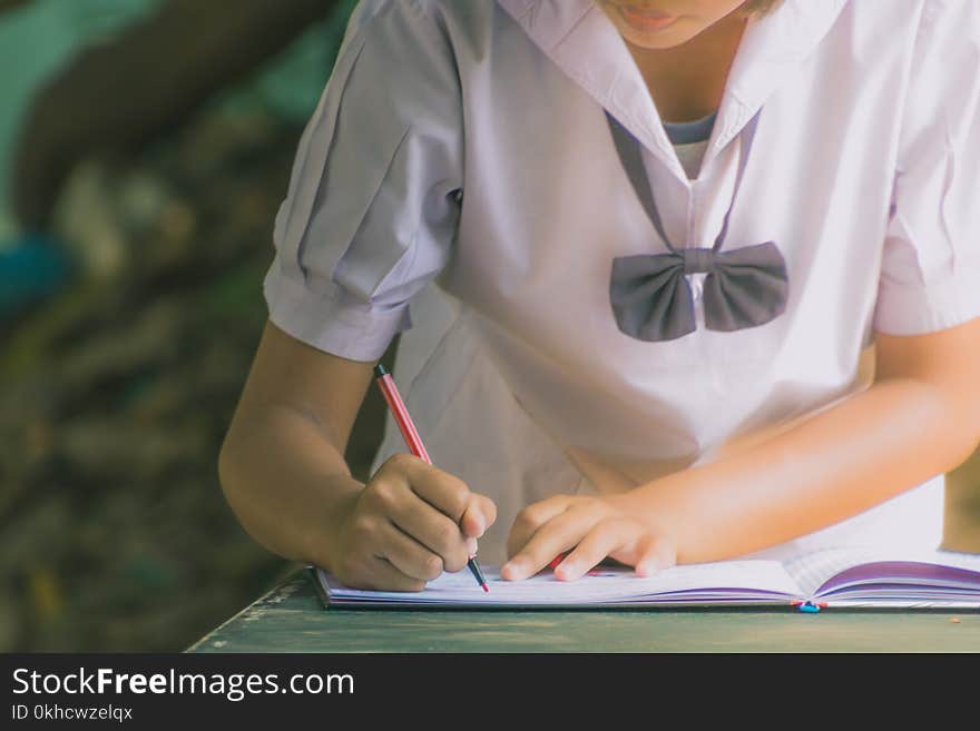 Female student write a notebook for graduates in secondary schoo