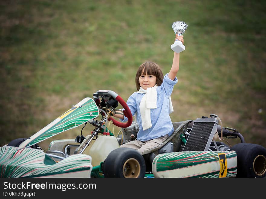 Cute child, riding go cart, wins champion cup