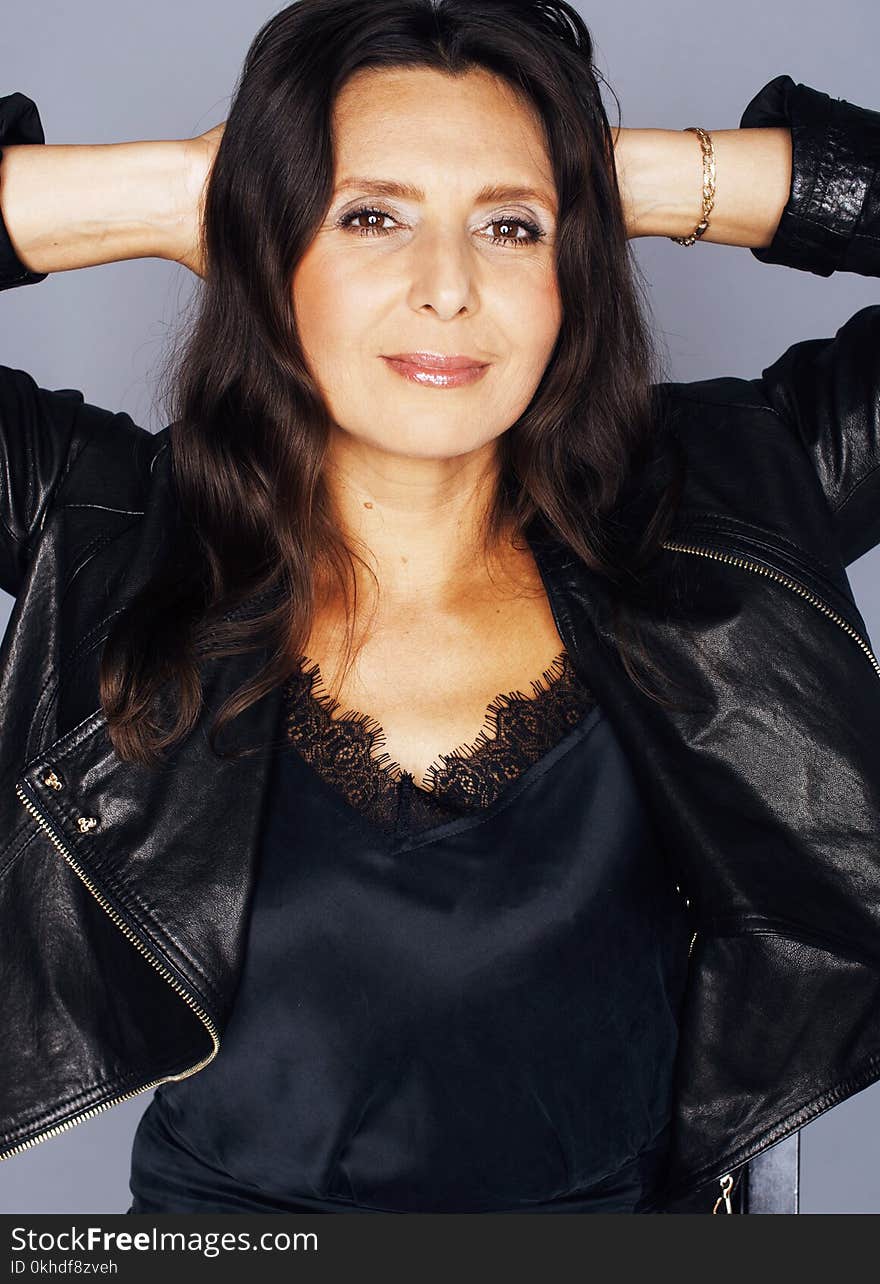 Pretty brunette confident mature woman sitting on chair in studio, lifestyle people concept close up