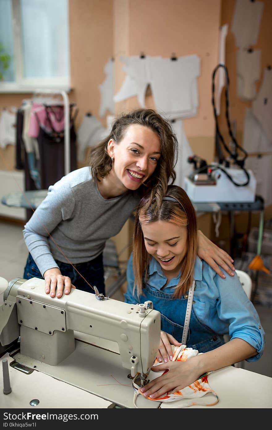 Two women, dressmakers, work in the workshop