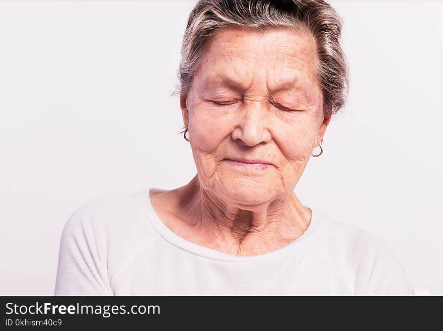 Portrait of a senior woman with closed eyes in a studio. Close up. Portrait of a senior woman with closed eyes in a studio. Close up.