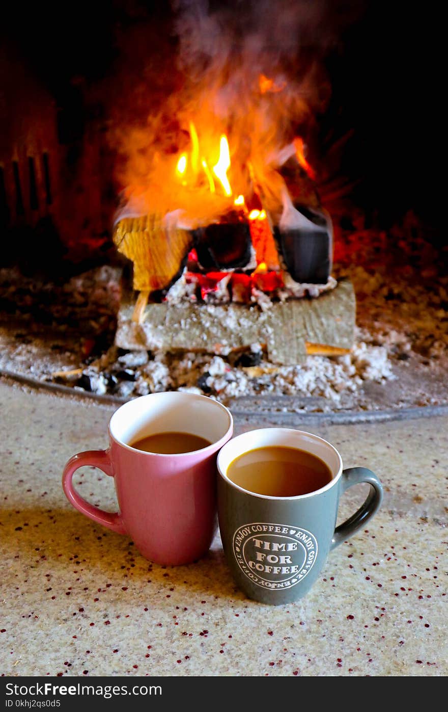 Bright colorful flame, burning wood at the fireplace, two coffee