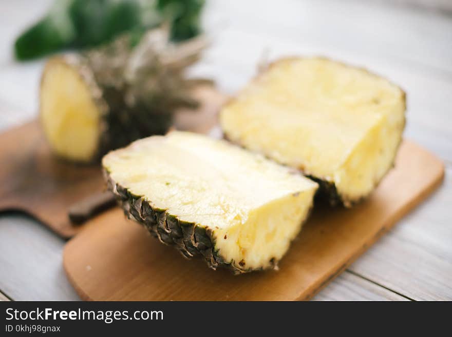 Sliced fresh pineapple on a wooden background in sunlight.