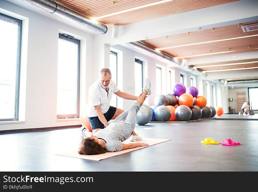 Senior physiotherapist working with an old female patient.