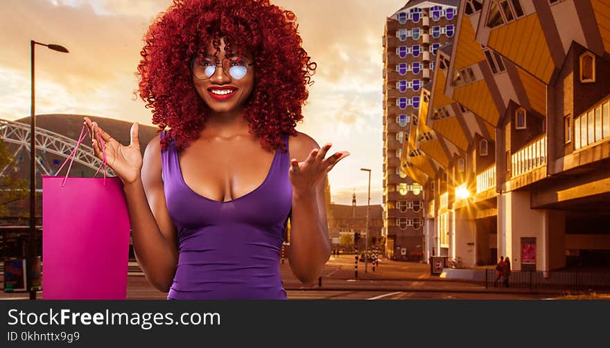 Afro american woman at shopping holding pink bag isolated on orange background on black friday holiday. Copy space for