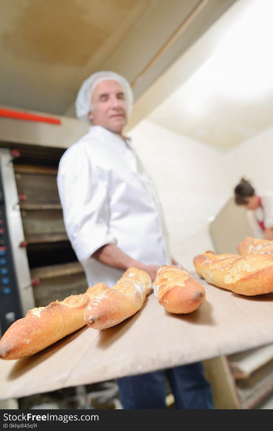 Baker holding five baguettes on paddle