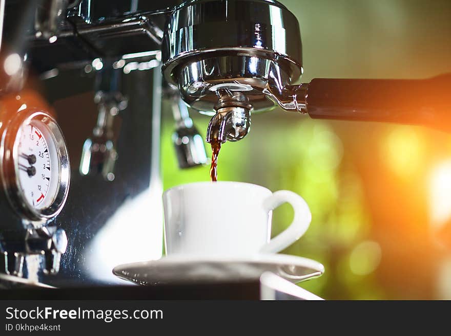 Espresso pouring from classic coffee machine into small white cup. Close-up Shot. Espresso pouring from classic coffee machine into small white cup. Close-up Shot.