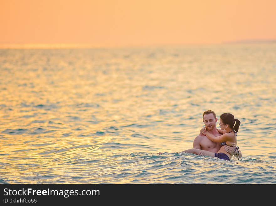 Man and Woman Swimming in a Beach