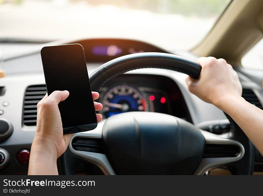 Person Holding Black Smartphone and Vehicle Steering Wheel