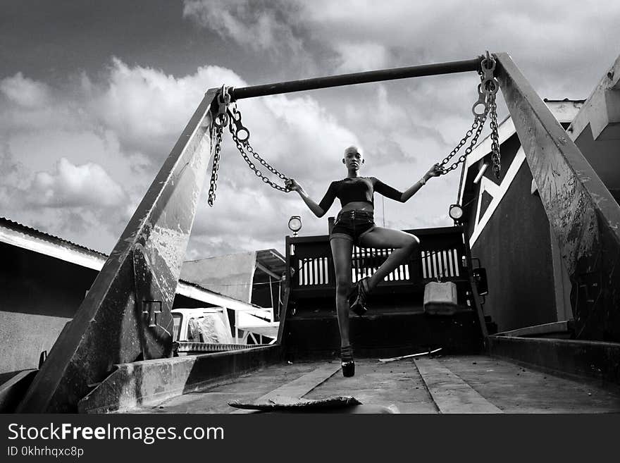 Photo of Bald Woman Holding Two Chains