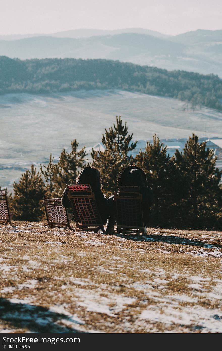 Photo of Two Woman Sitting on Folding Chair