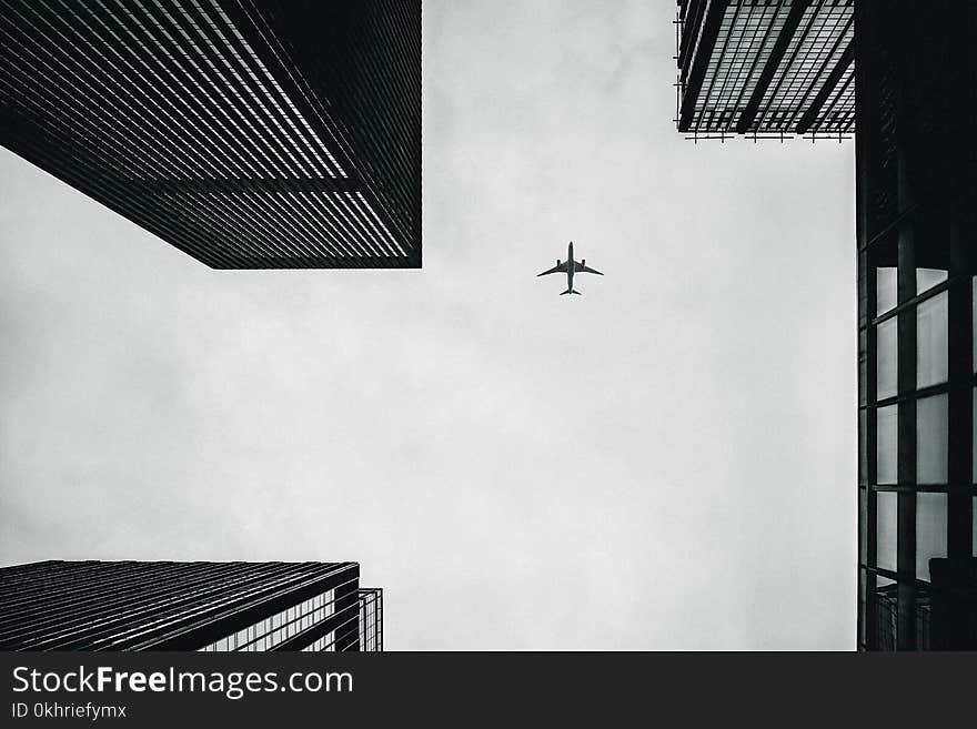 Low Angle Photography of Airplane And Buildings