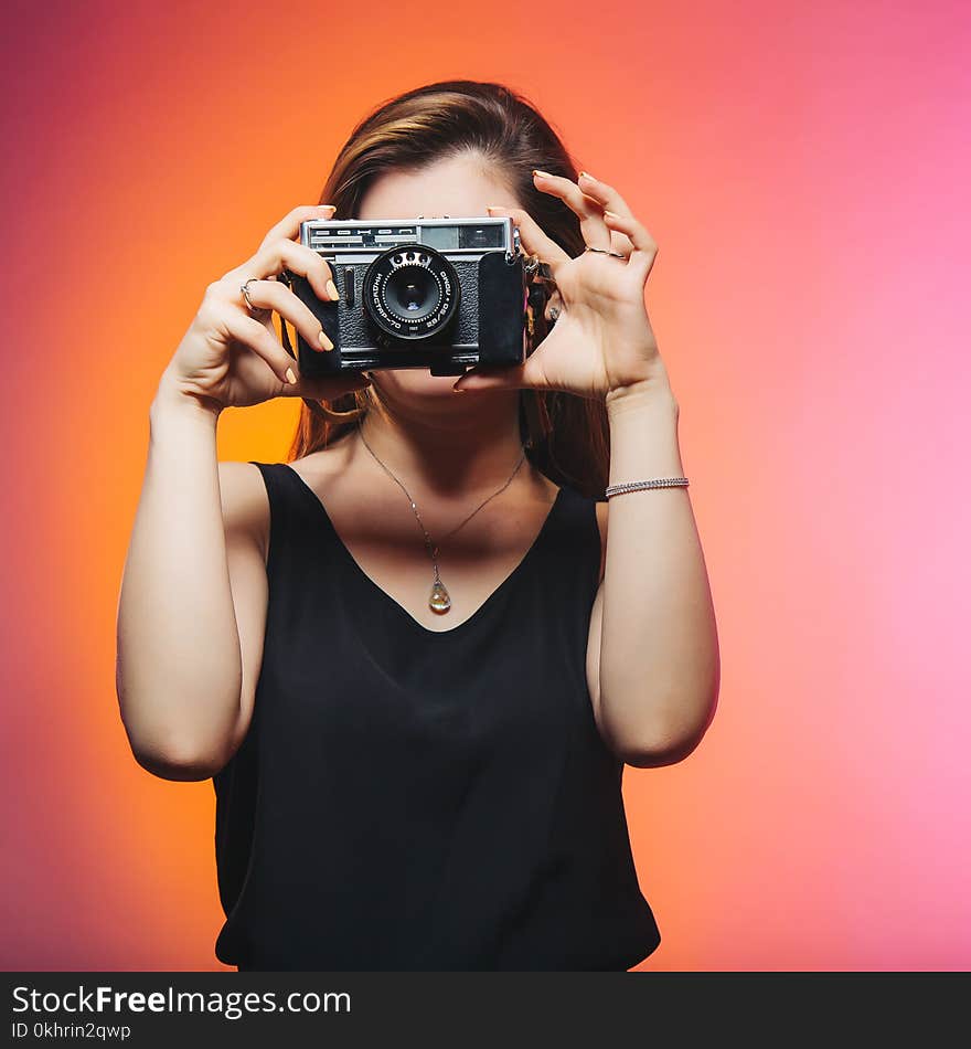 Woman Wearing Black Sleeveless Top Holding Gray Camera