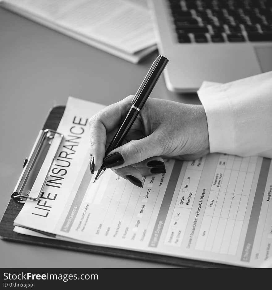 Grayscale Photo of Person Holding Pen