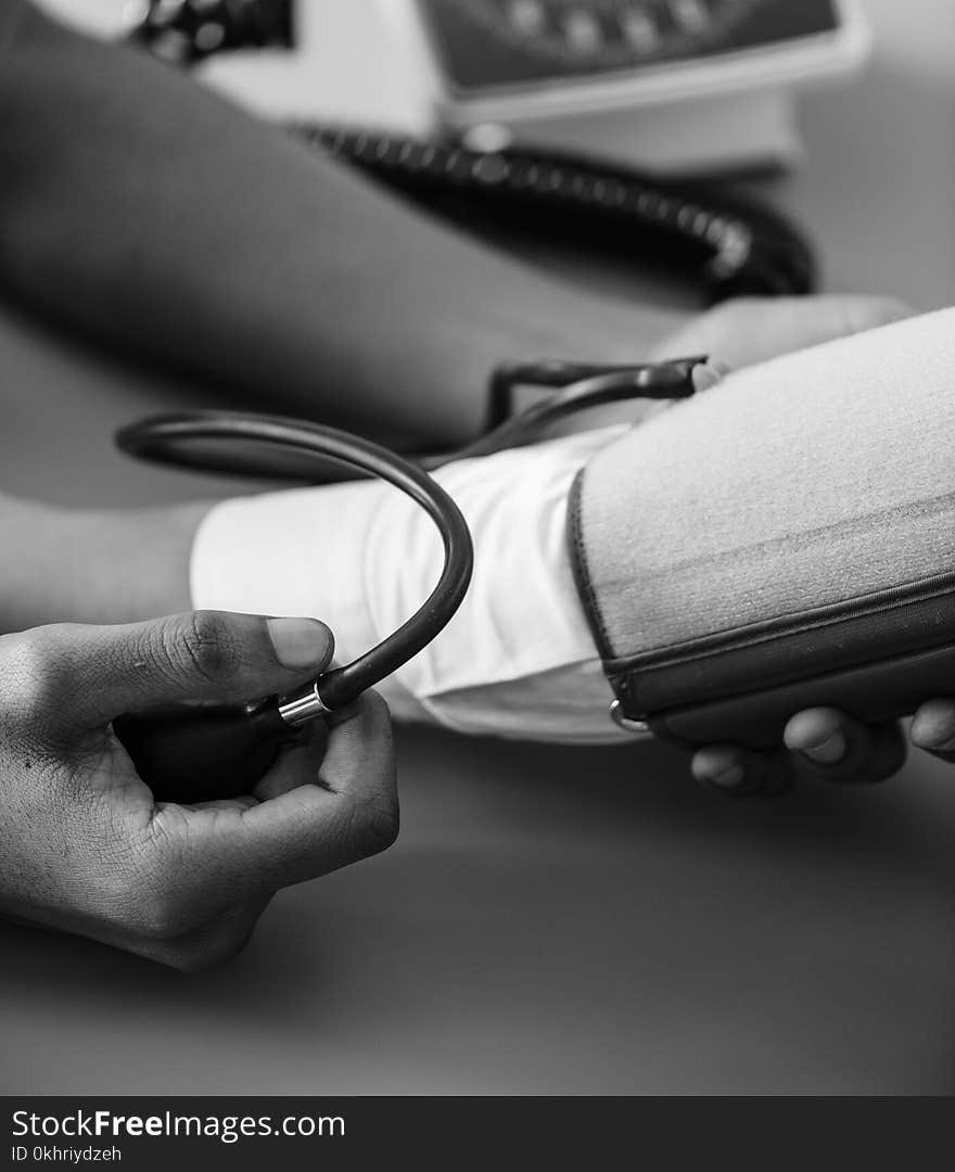 Greyscale Photo of Person Taking Blood Pressure