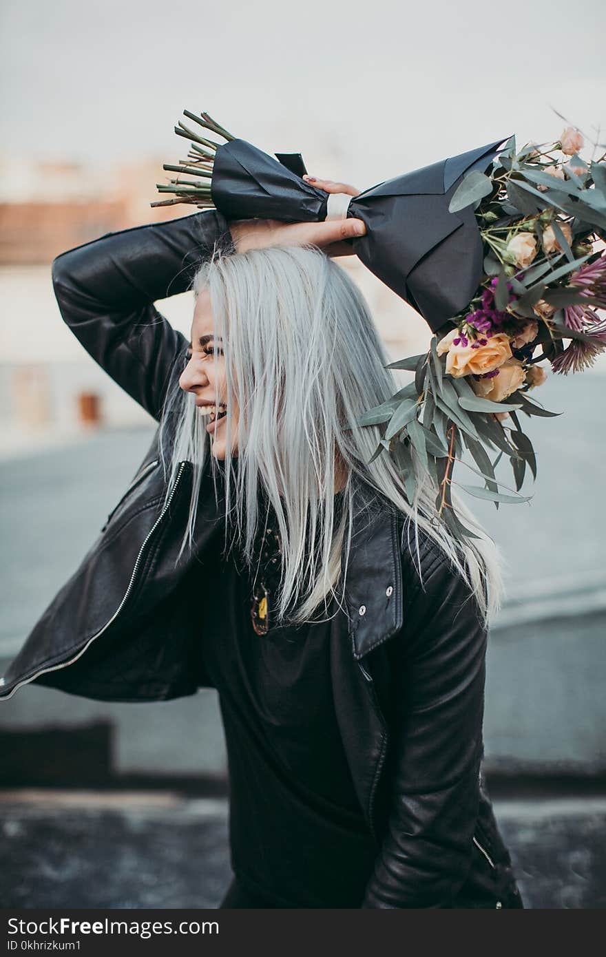 Woman Wearing Black Leather Jacket Holding Flower Bouquet