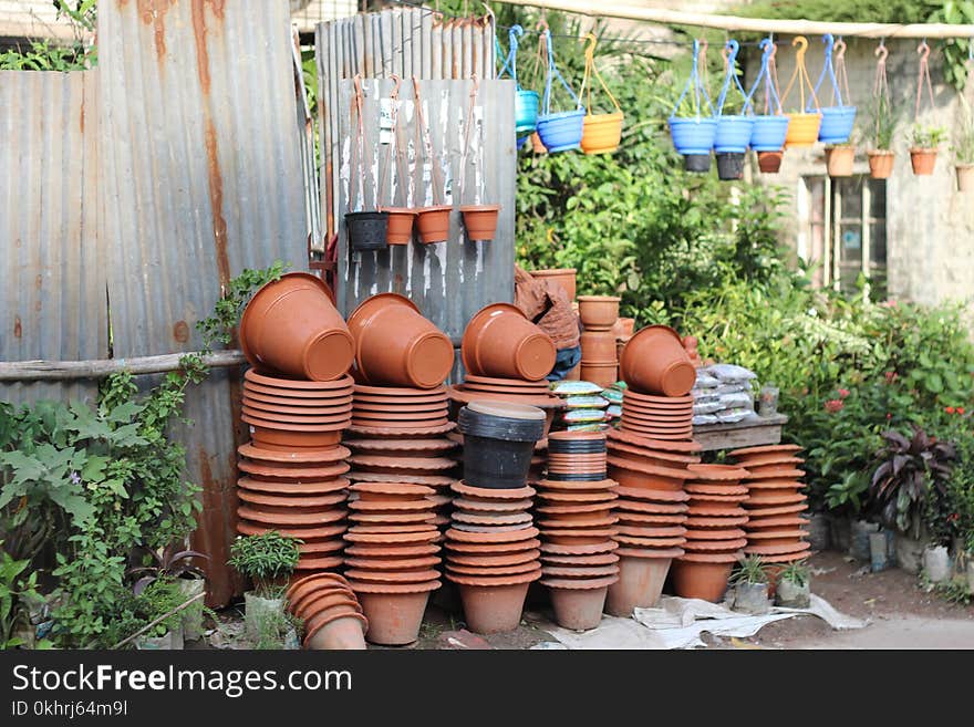 Stack of Clay Pots Beside Tin Roof