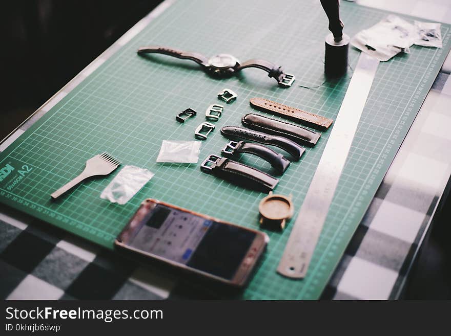 Watch With Straps Beside Smartphone on Table