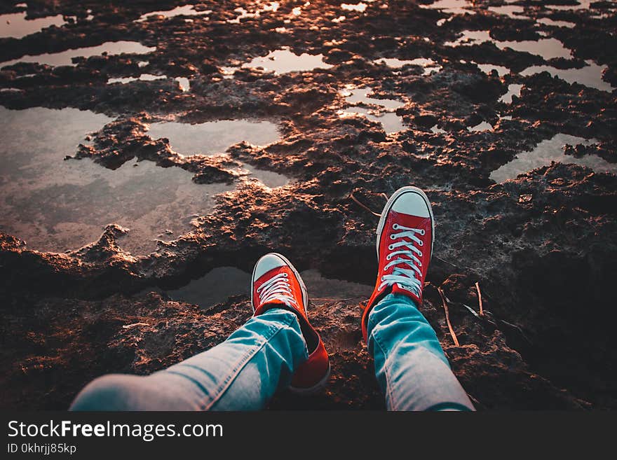 Person Wearing Red Low-top Sneakers and Jeans