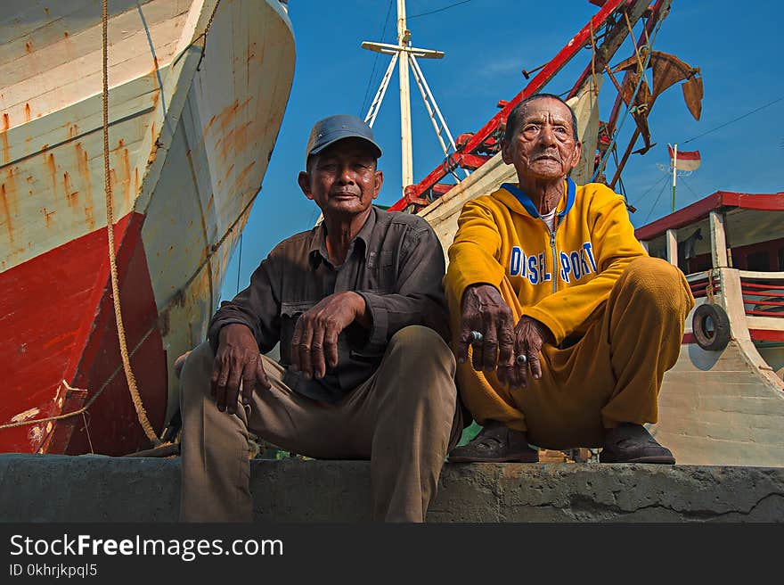 Candid Photography of Two Male Sitting on Gray Pavement