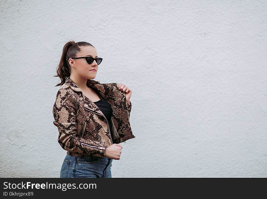 Photo of Woman Wearing Brown-and-black Snakeskin Jacket Beside Wall