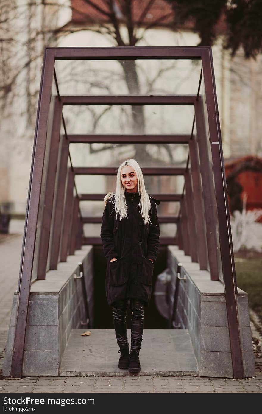 Woman in Black Coat Standing Near Staircase