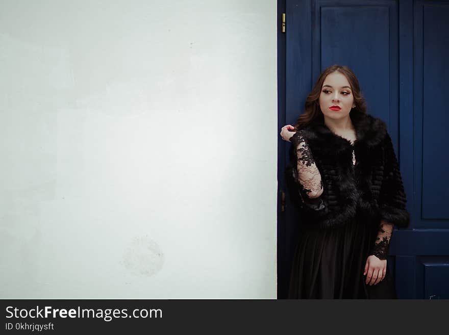 Woman Leaning on Blue Door