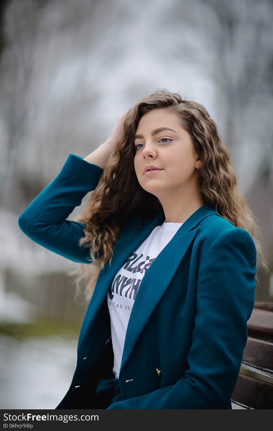 Woman Wearing Green Peak Lapel Suit Jacket Sitting on Bench