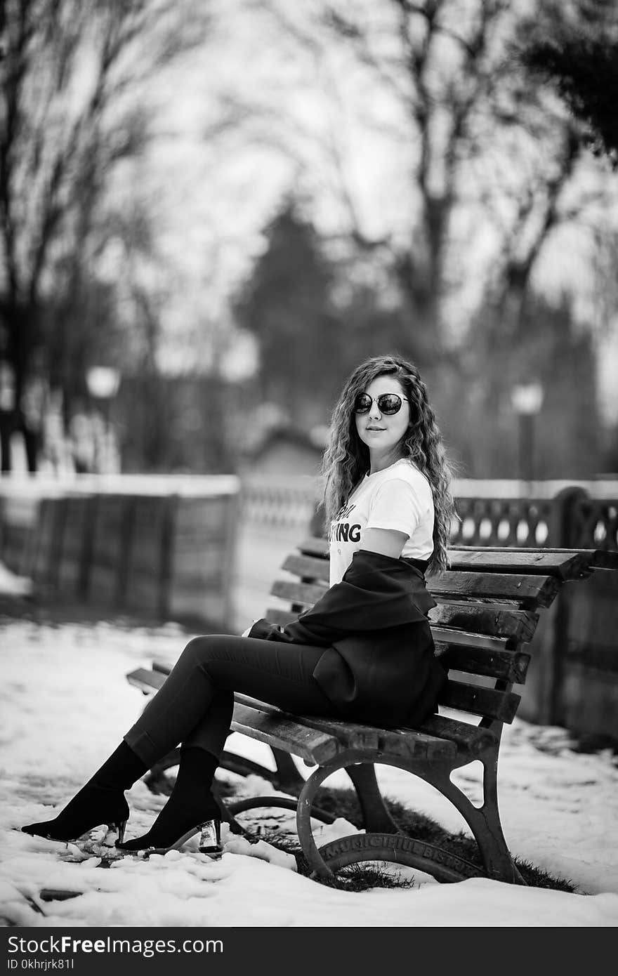 Grayscale Photography of Woman Sitting on Bench