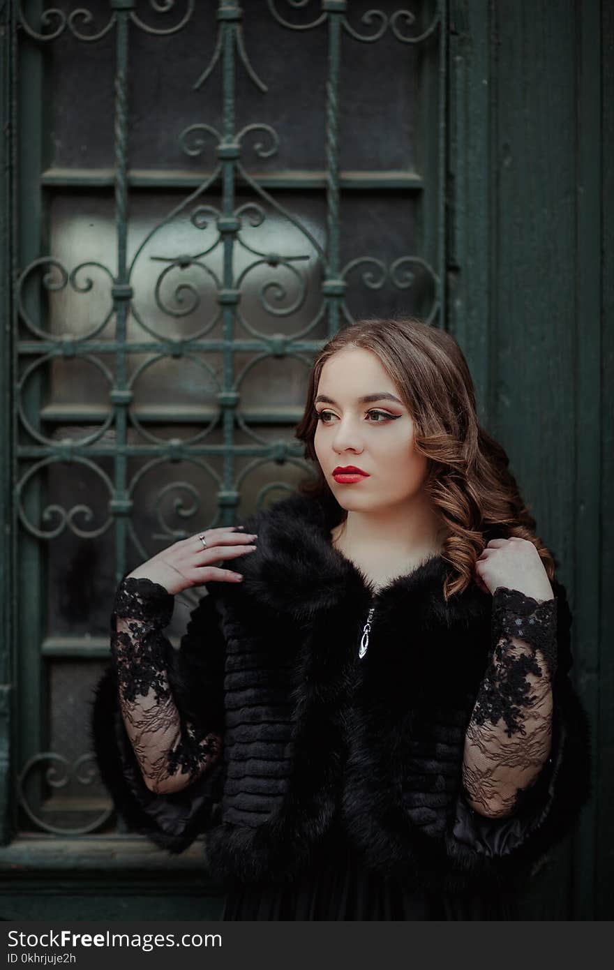 Woman Standing in Front of Black Metal Gate