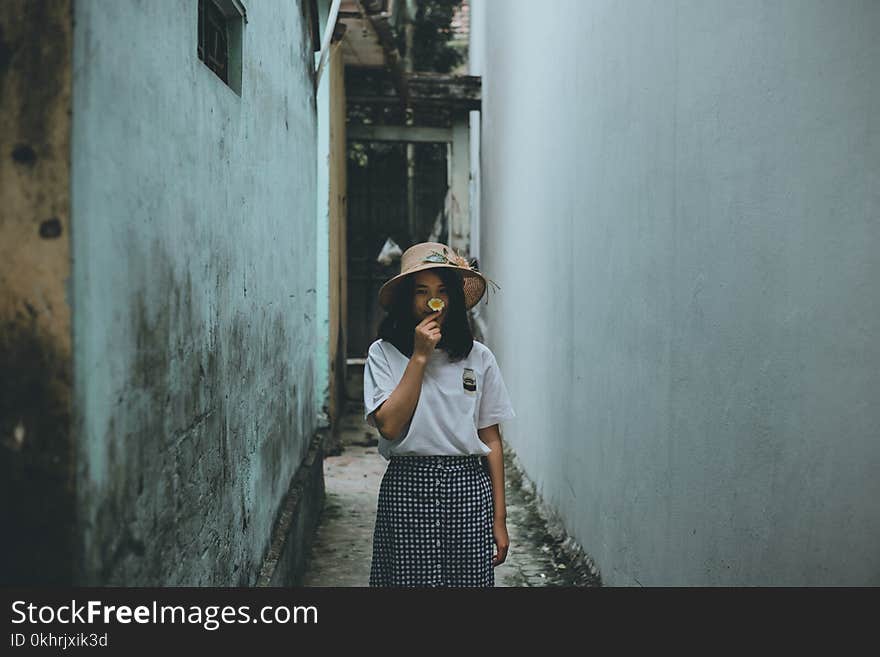 Woman in Gray Crew-neck Shirt in Middle of White and Teal Concrete Alley