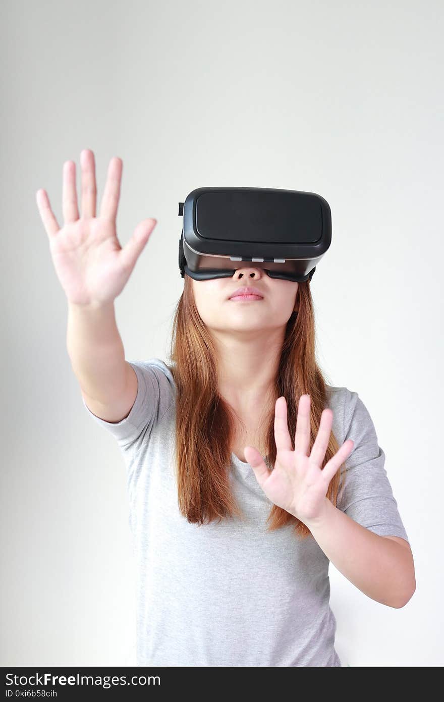 Young woman wearing virtual reality glasses at home. A virtual reality headset is a head-mounted device that provides virtual reality for the wearer.