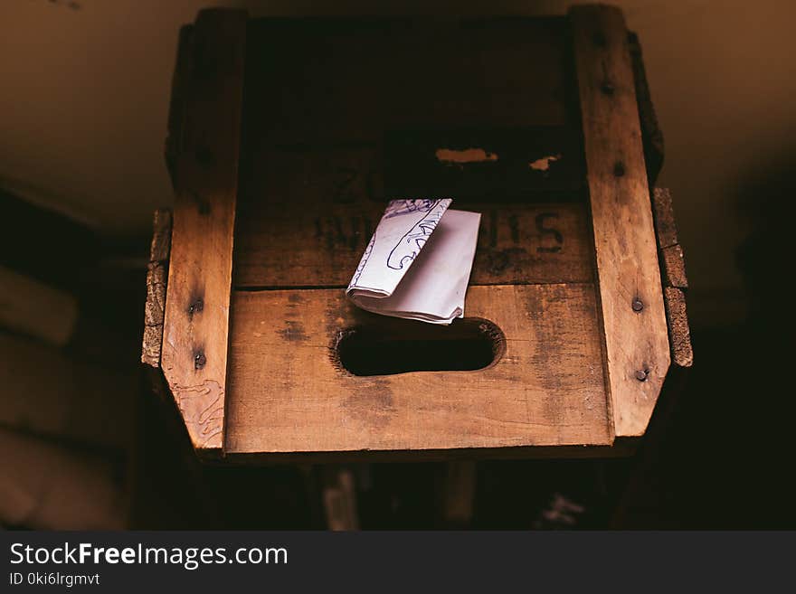 White Printing Paper on Brown Wooden Crate