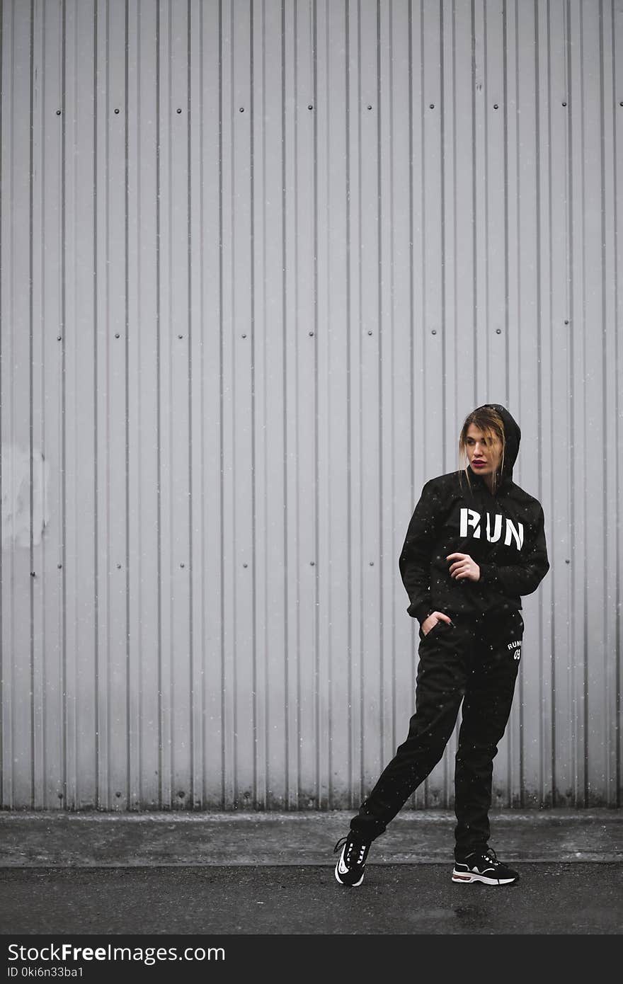 Woman in Black Hoodie, Pants, and Sneakers