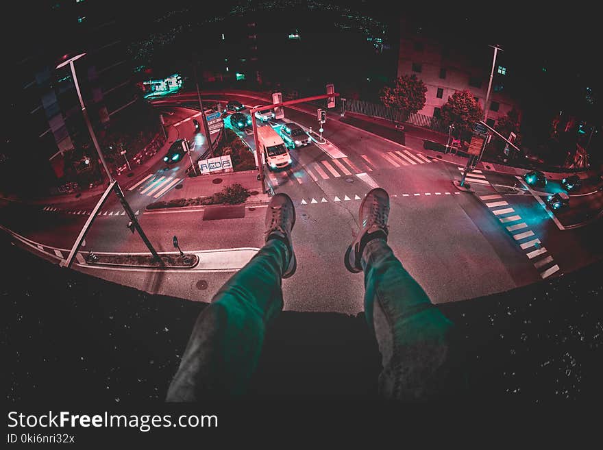 Person Sits on Building during Nighttime