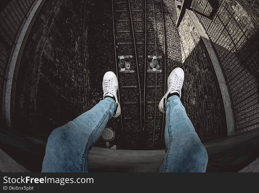 Person in Blue Denim Stonewashed Fitted Jeans and White Low-top Sneakers