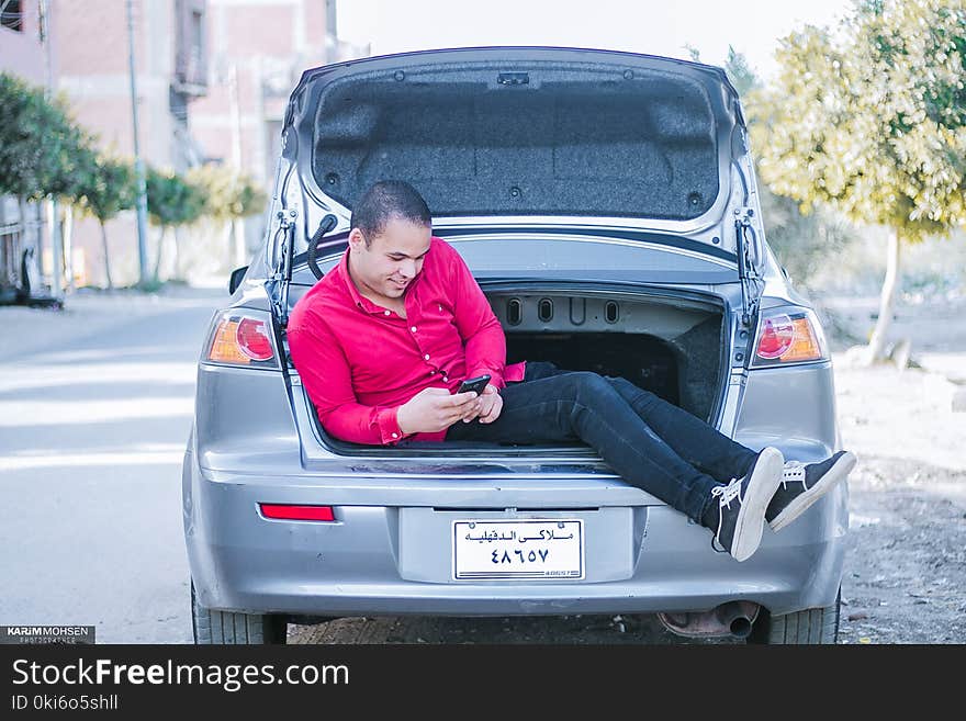 Man Seating on Car Trunk