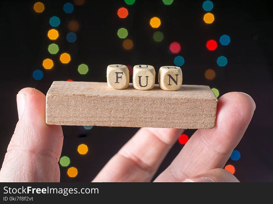 Fun wording in hand cubes bokeh lighton a dark background. Fun wording in hand cubes bokeh lighton a dark background