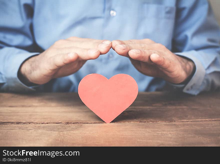 Businessman protecting red heart.