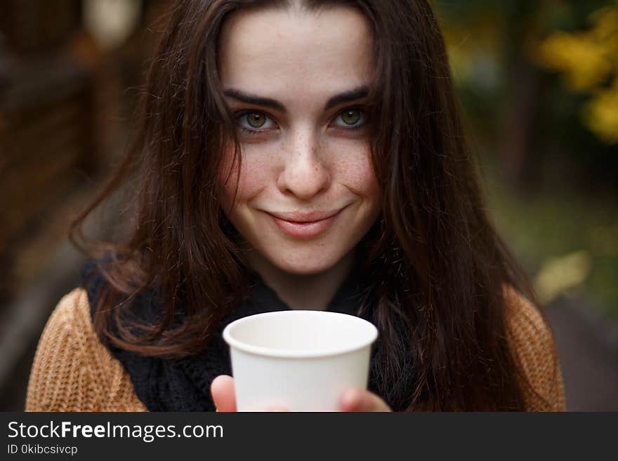 Close up portrait of young pretty smiling woman wearing knitted